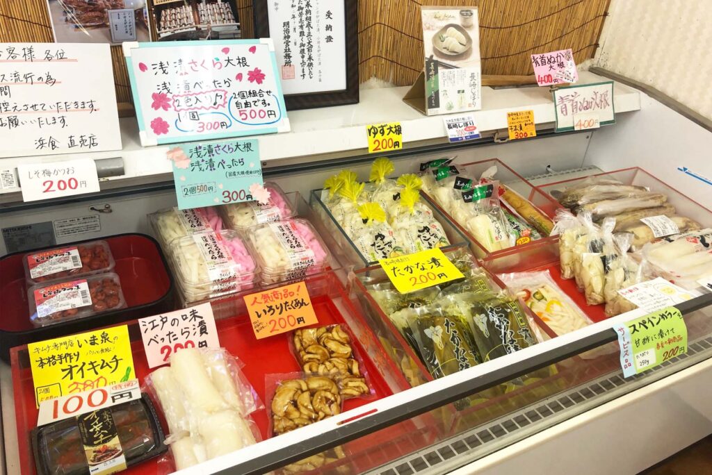 浜食店内で炉ばた漬を手に持った笑顔の女性